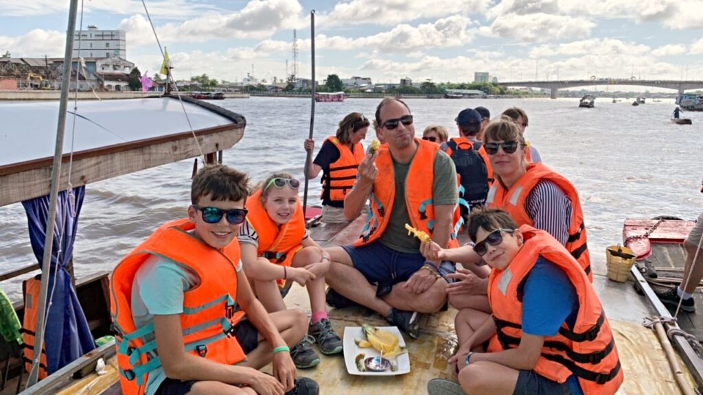 A group of our happy tourists, riding a boat on the Mekong River.