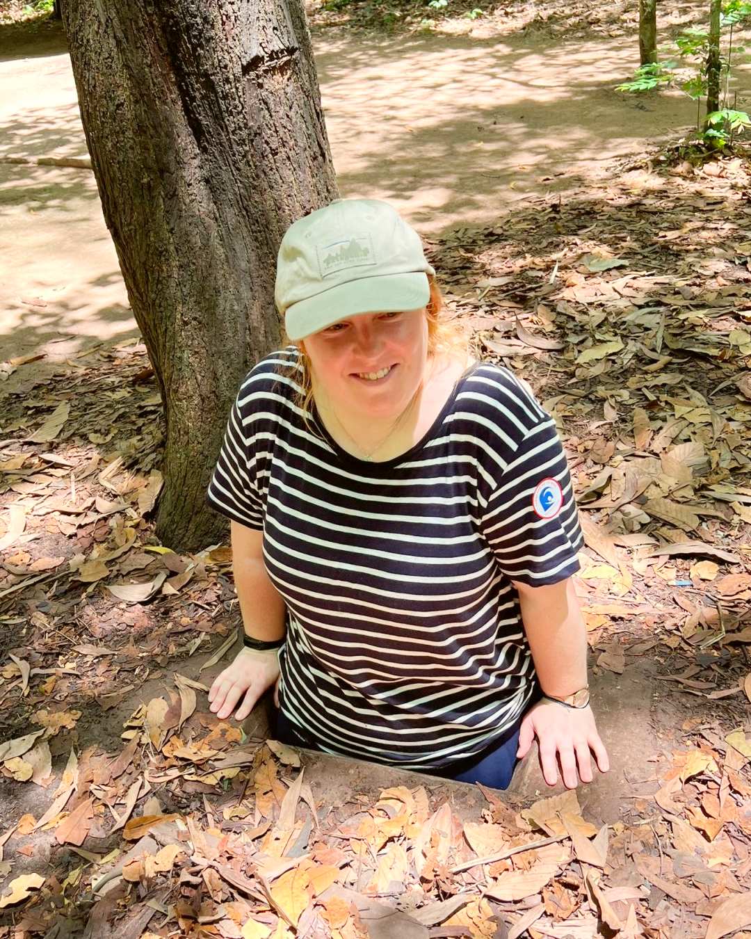 A traveler emerging from a tunnel at Cu Chi.