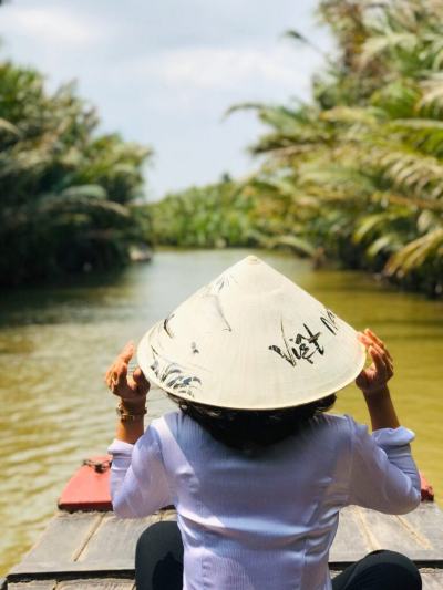 A One Vietnam tour guide on a sampan, guiding a tour
